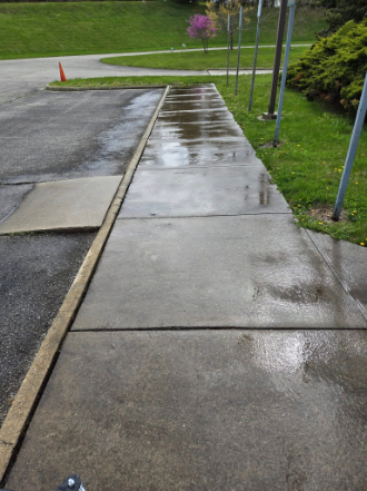 Clean driveway and grounds near a commercial entrance